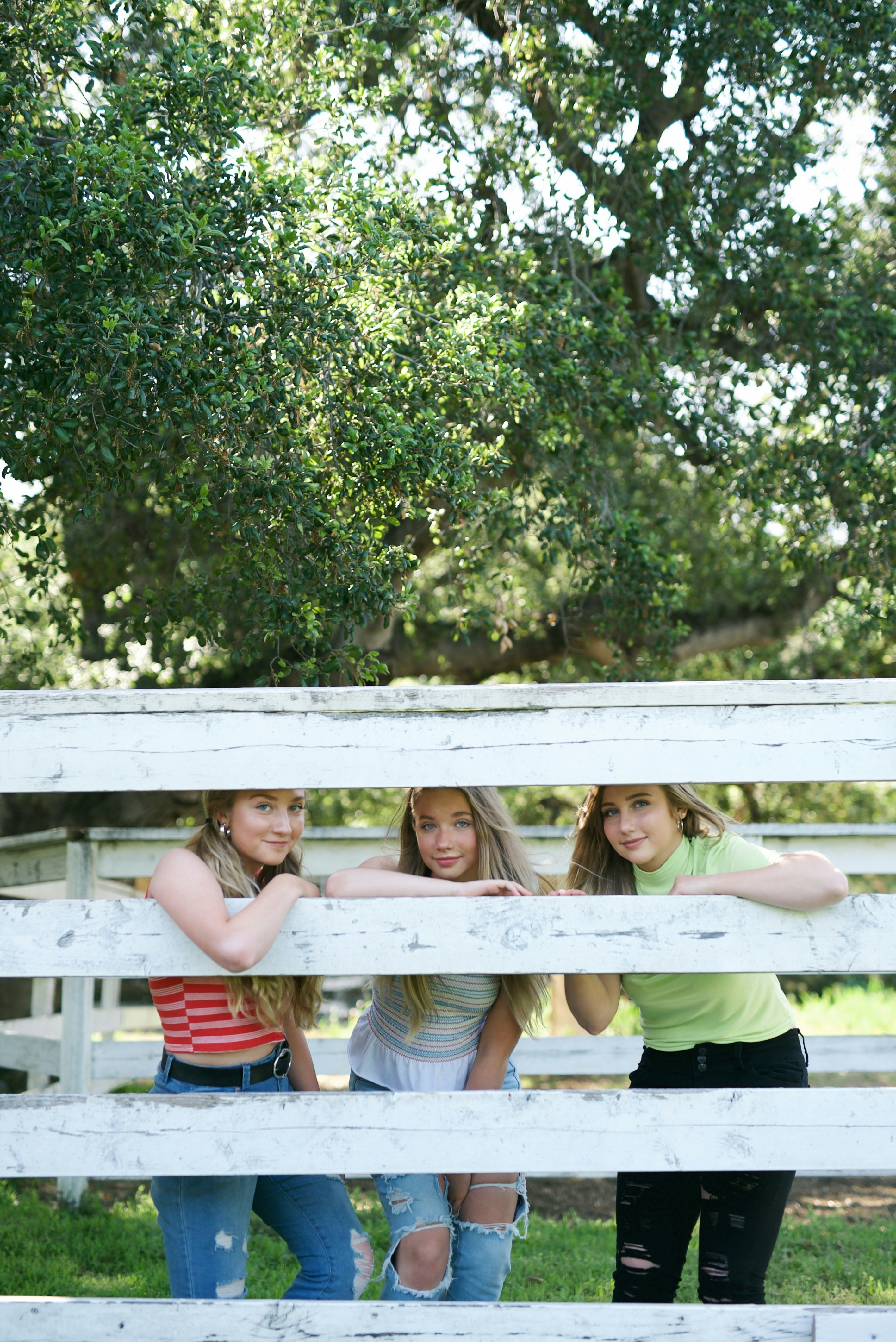 2 women sitting on white bench